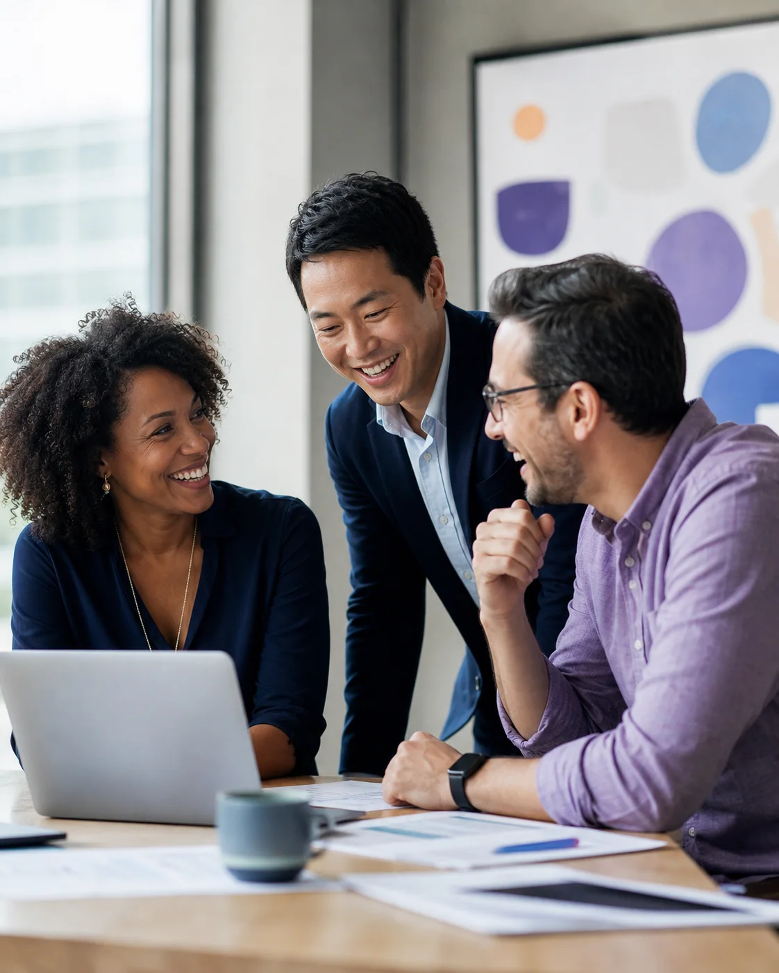 Three service-business leaders smiling around a laptop